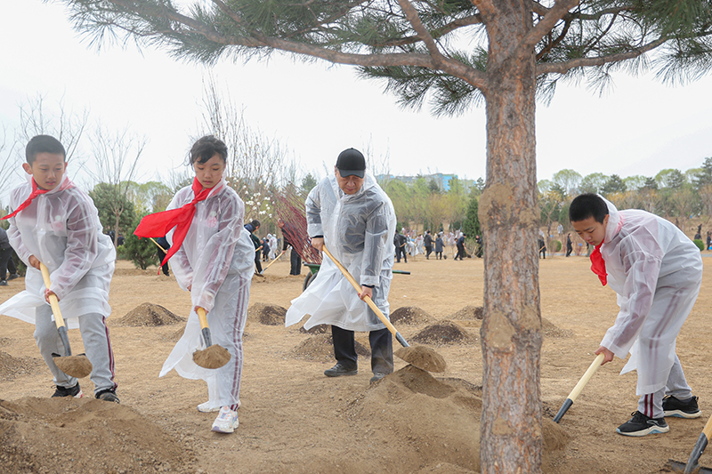 4月4日，党和国家领导人习近平、李强、赵乐际、王沪宁、蔡奇、丁薛祥、李希、韩正等冒雨来到北京市朝阳区东坝中心公园参加首都义务植树活动。这是习近平同大家一起植树。